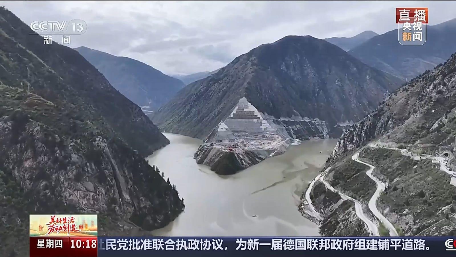 截图取自央视新闻对双江口水电站库区完成一期蓄水的新闻报道，图中央便是甲扎尔甲山洞窟壁画原址所在地，部分山脊已被夷平成为工地，山腰以下也被淹没 