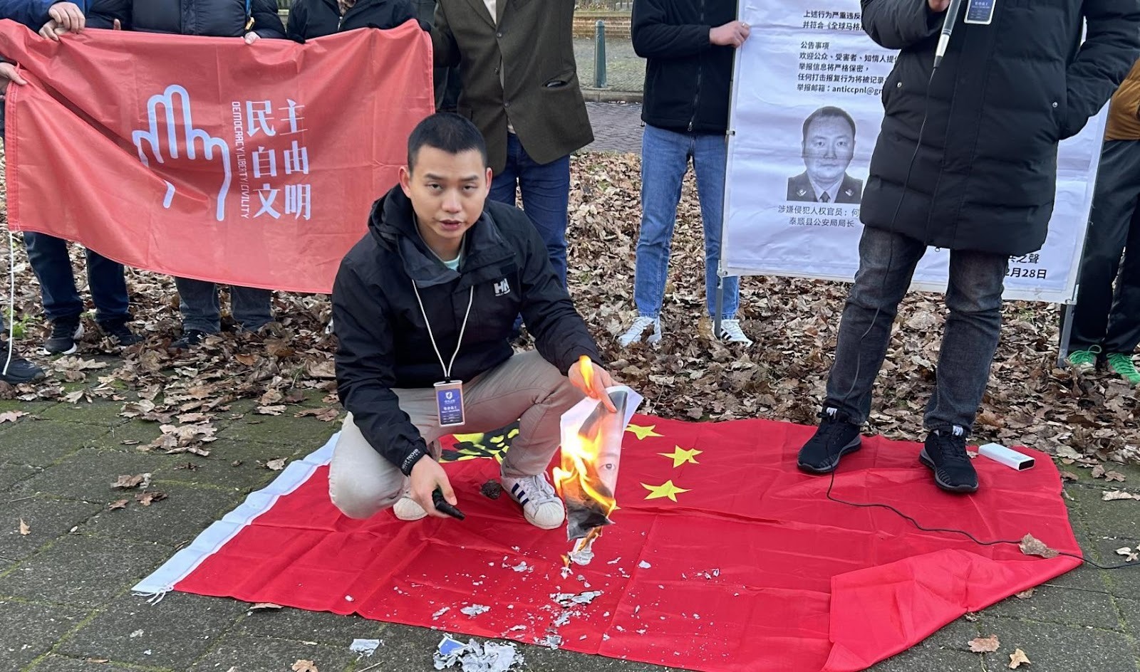 活动义工江培坤现场焚烧涉嫌侵犯人权的官员照片，活动义工江培坤提供 