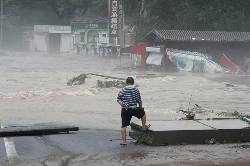 8月1日，一名门头沟男子站在高处向被洪水摧毁的城镇望去。(AP: Ng Han Guan) 