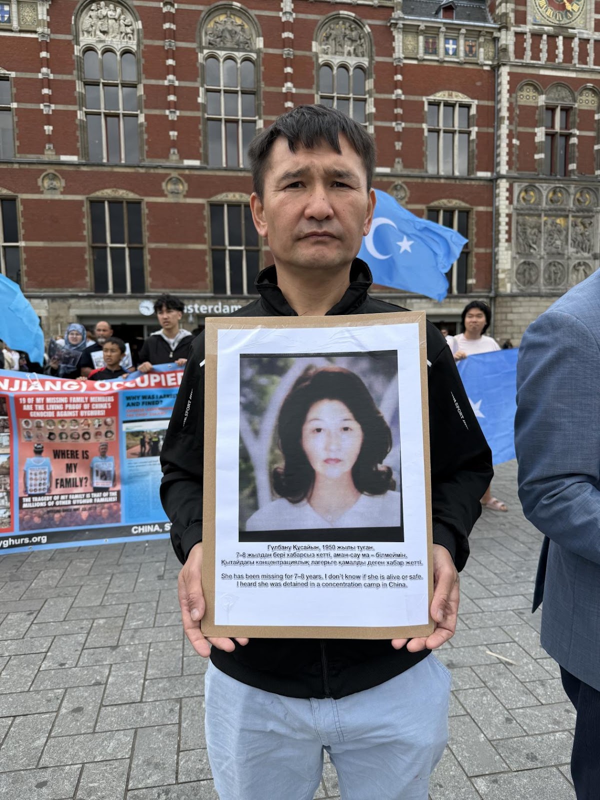 现场手举失踪家人照片的维吾尔人